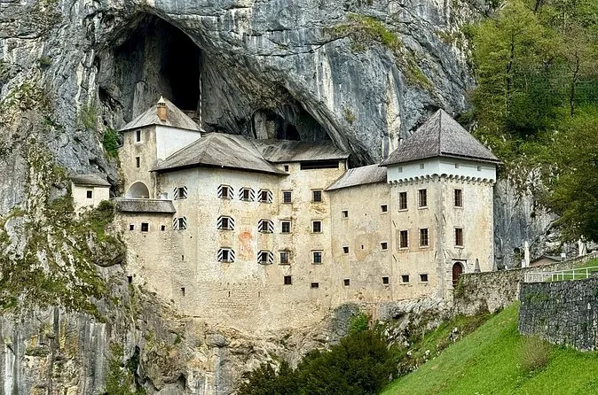 Die weißen Mauern und Türme von Burg Predjama, unter einem Höhlenüberhang in den Fels gebaut